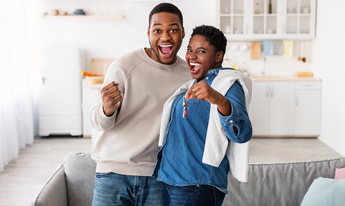 Happy African American couple showing keys of their new apartment - JN Bank
