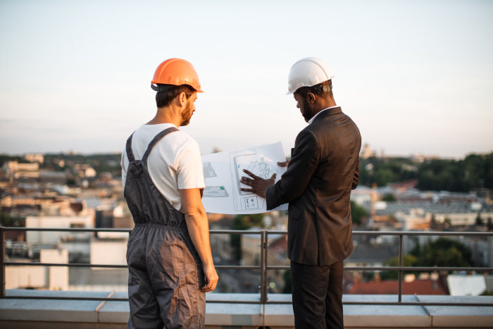 workman-presenting-blueprints-to-urban-planner-on-2023-07-25-18-15-35-utc (1) - JN Bank
